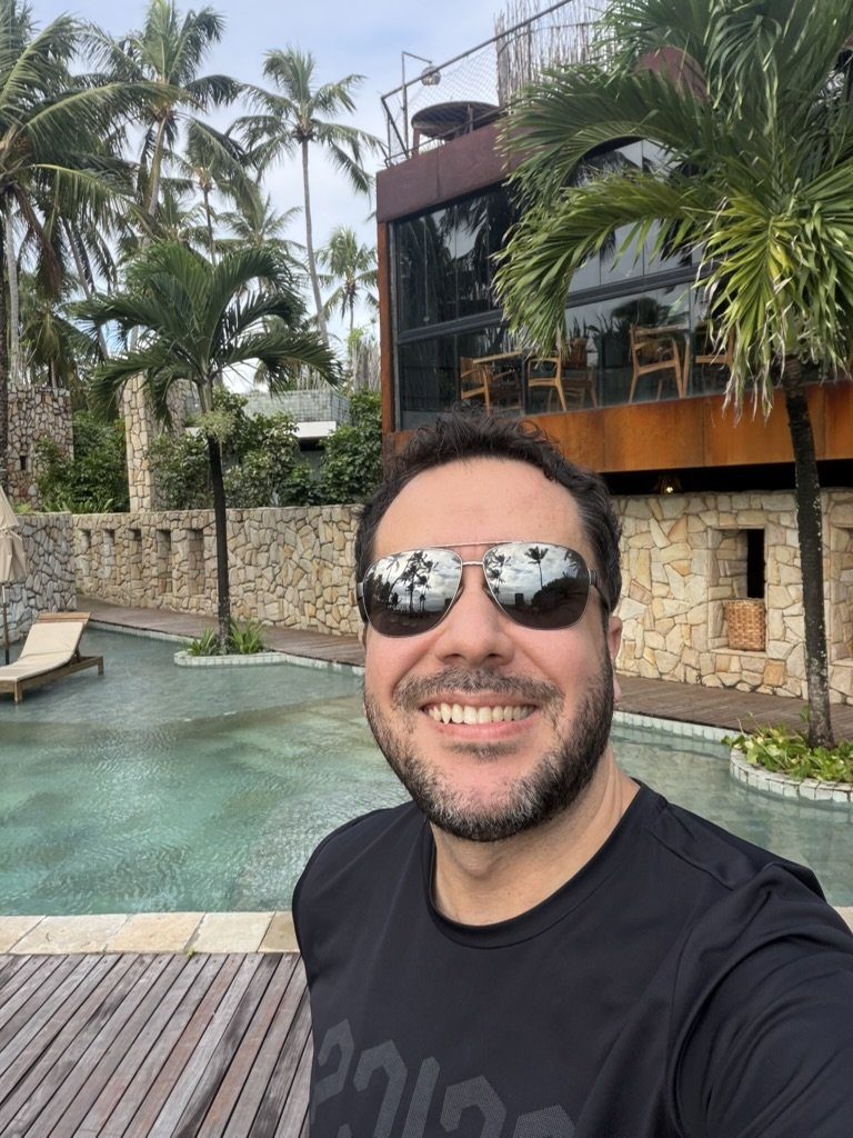 Fachada de aço corten do restaurante do Pedras do Patacho sobre as piscinas, com muros de pedra ao redor