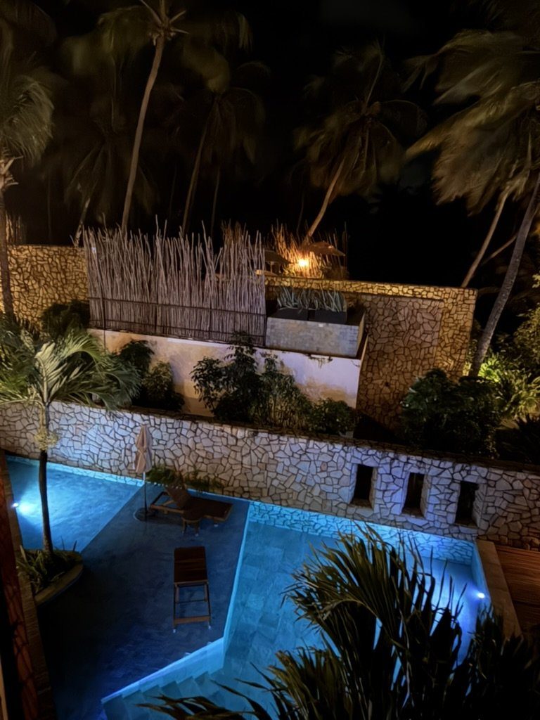 Piscinas iluminadas em azul à noite entre os muros de pedra do Pedras do Patacho